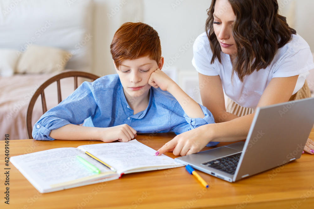 Mom helps her son with online homework. Close-up photo. Mom helps her son with online homework. Close-up photo.