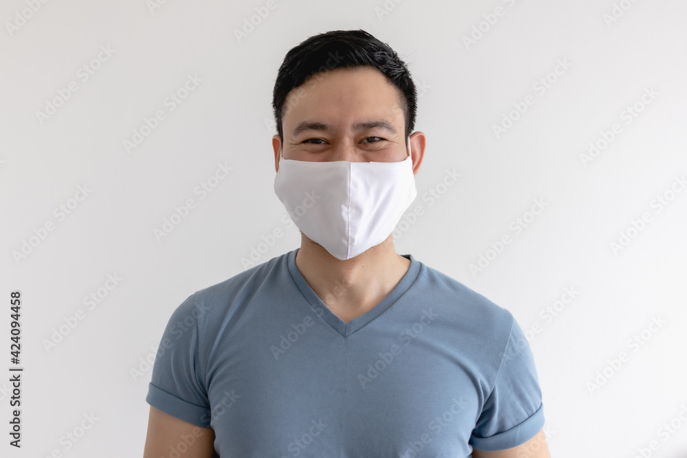 Happy and pleased expression of Asian man in white mask on isolated background.