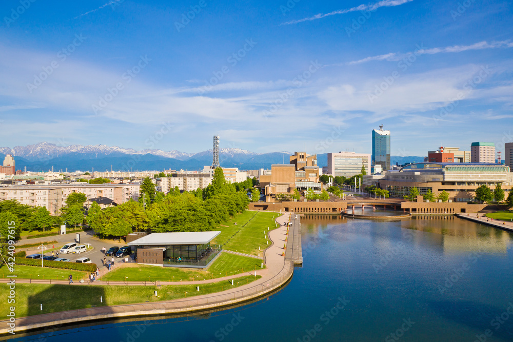 Obraz premium Toyama cityscape and Tetayama mountain range (Japan alps) views from Kasui park in Toyama city, Toyama, Japan.
