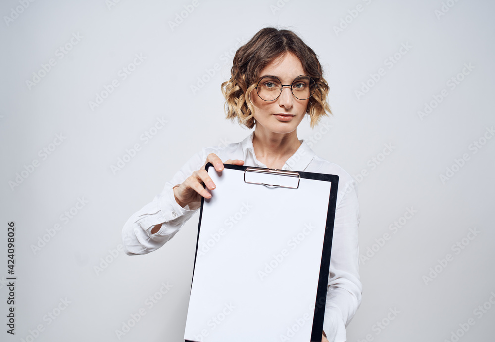 Naklejka premium Business woman with a folder of documents in her hands and a white sheet of paper mockup