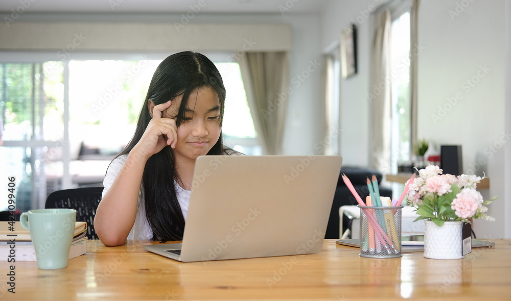 Fototapeta premium Asian girl student using digital tablet for online lesson at home.