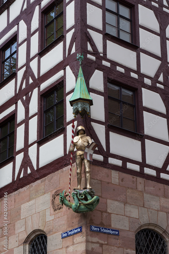 Corner of a half timbered house decorated with a sculpture of a knight