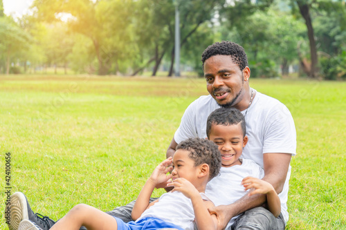 Cheerful african american father and two sons playing in park, Happiness family concepts, parent and childs play in park © JU.STOCKER
