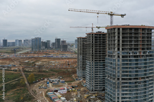 Construction cranes standing near multi storey buildings