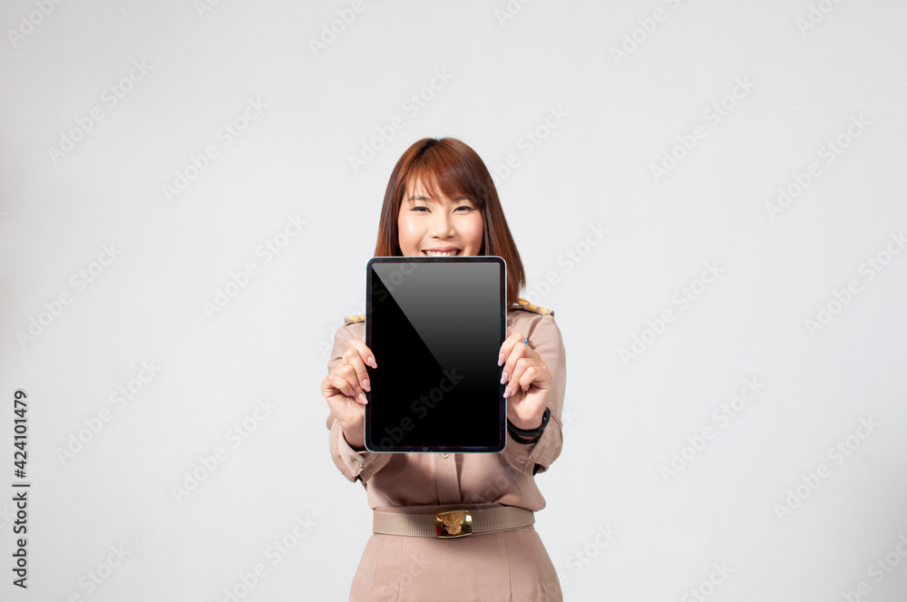Female thai teacher in uniform standing with white background holding a tablet to the front Female thai teacher in uniform standing with white background holding a tablet to the front