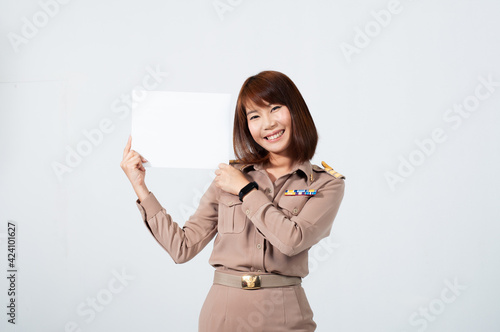 Female thai teacher in uniform standing with white background holding a white paper