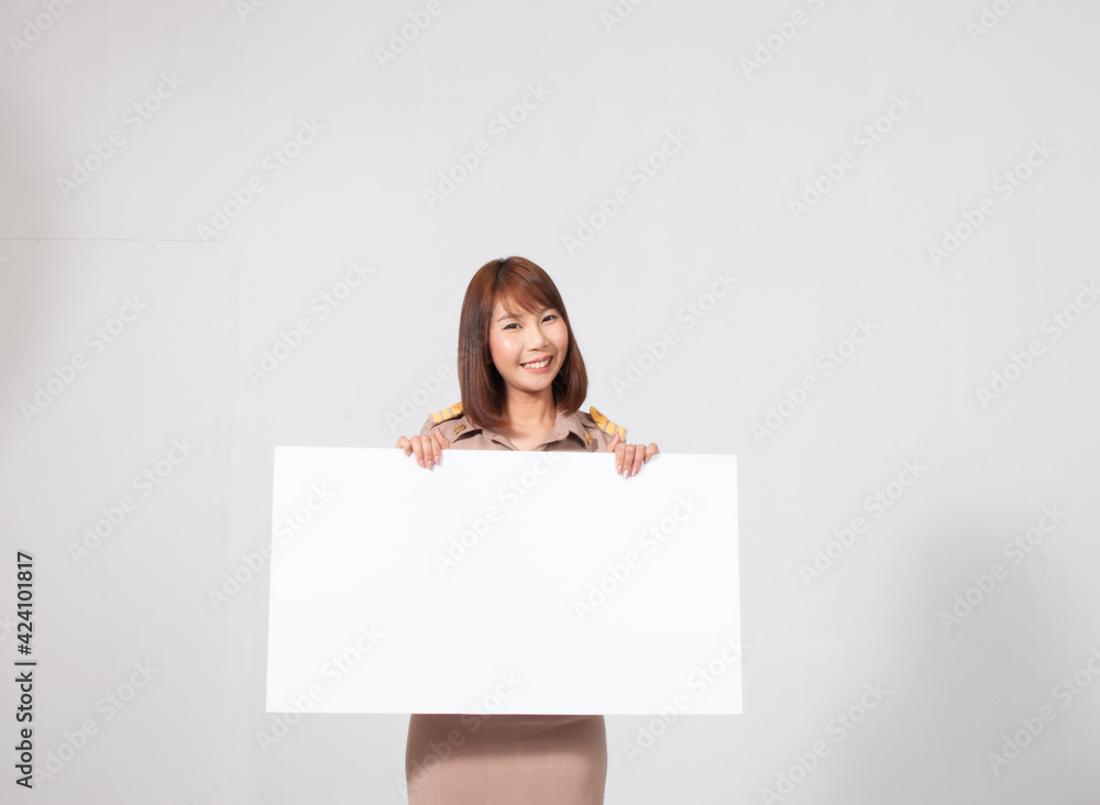 Female thai teacher in uniform standing with white background holding white paper Female thai teacher in uniform standing with white background holding white paper