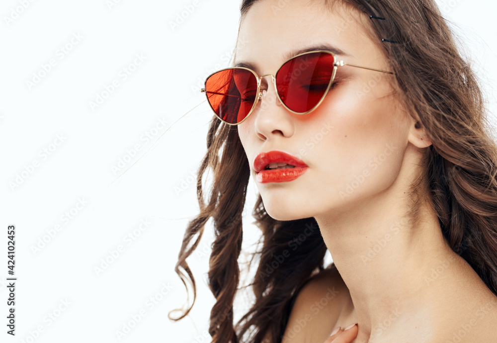 Portrait of a beautiful woman with bared shoulders and in sunglasses on a light background Portrait of a beautiful woman with bared shoulders and in sunglasses on a light background