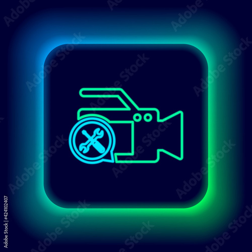 Glowing neon line Video camera with screwdriver and wrench icon isolated on black background. Adjusting, service, setting, maintenance, repair, fixing. Colorful outline concept. Vector