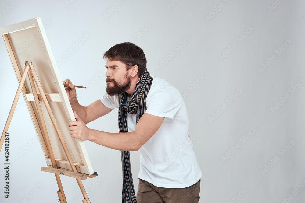 male artist painting on easel art lifestyle light background male artist painting on easel art lifestyle light background