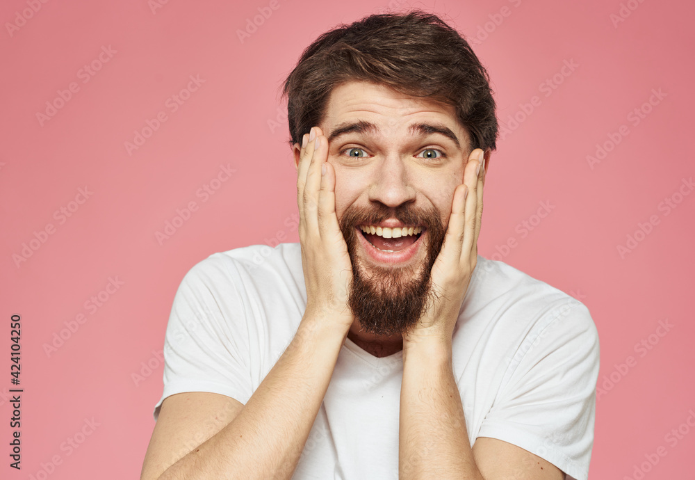 Portrait of a happy man with a beard on a pink background in a white T-shirt Portrait of a happy man with a beard on a pink background in a white T-shirt