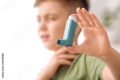 Little boy with inhaler at home, closeup