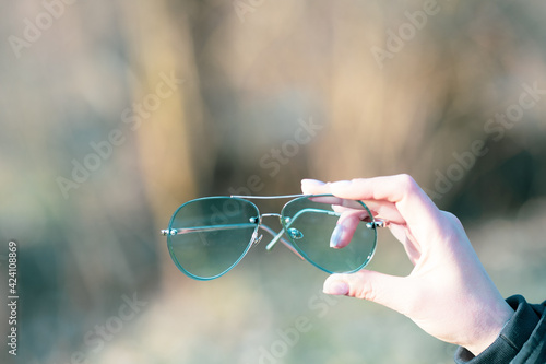 Aviator Sunglasses model with big green lenses for men shoot outside in a summer day closeup . Selective focus. High quality photo