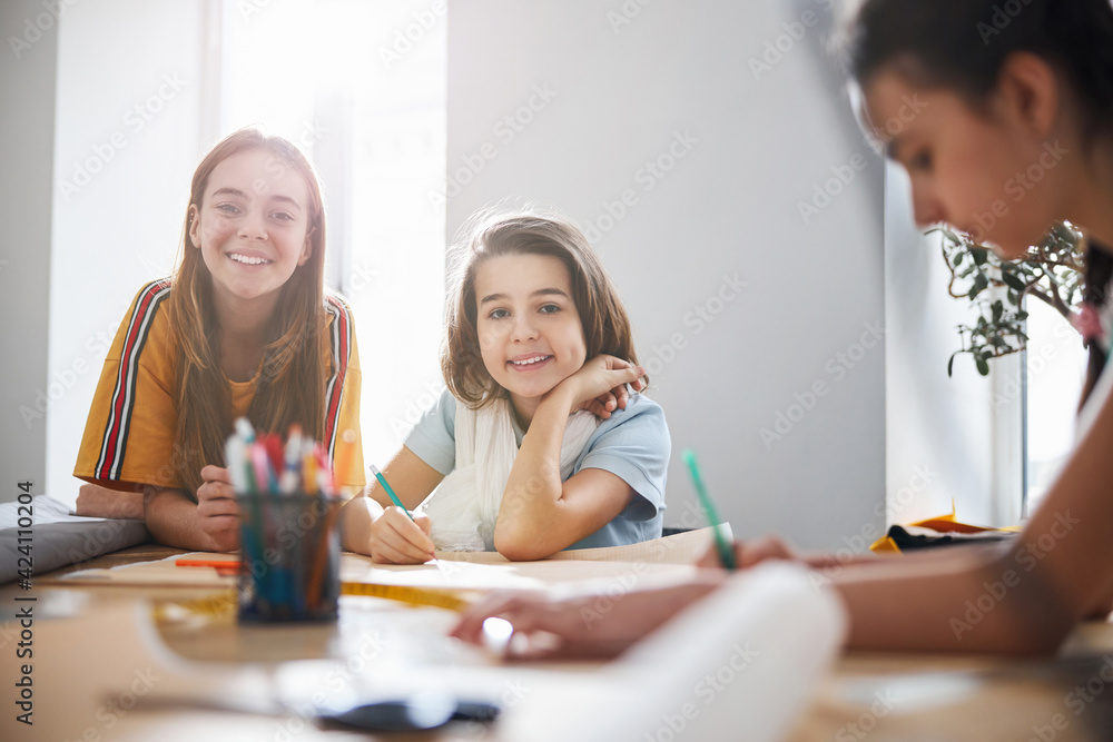 Adorable children drafting patterns in sewing workshop Adorable children drafting patterns in sewing workshop