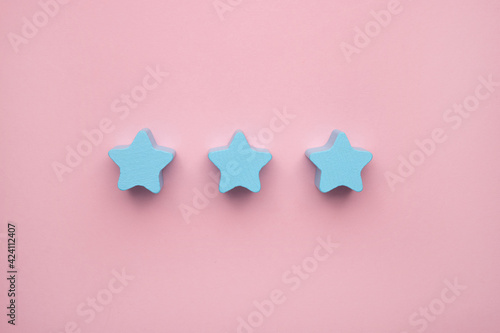 Top view on children's educational games, frame from multicolored kids toys on pink paper background. Wooden blue stars. Flat lay, copy space