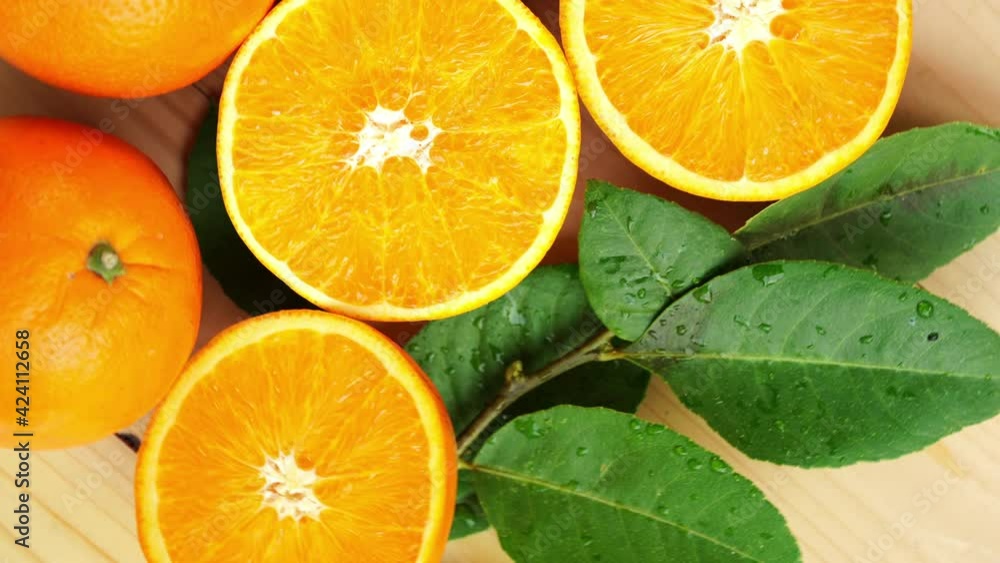 Orange fruit with slices closeup, Top view Rotate fruits, Sweet orange fruit with green leaves in the garden. Orange fruit with slices closeup, Top view Rotate fruits, Sweet orange fruit with green leaves in the garden.
