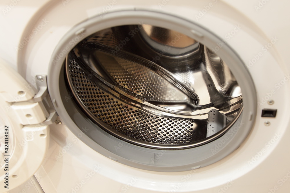 Front loaded slim washing machine empty can inside with shiny stainless steel rotor drum without water close-up Front loaded slim washing machine empty can inside with shiny stainless steel rotor drum without water close-up