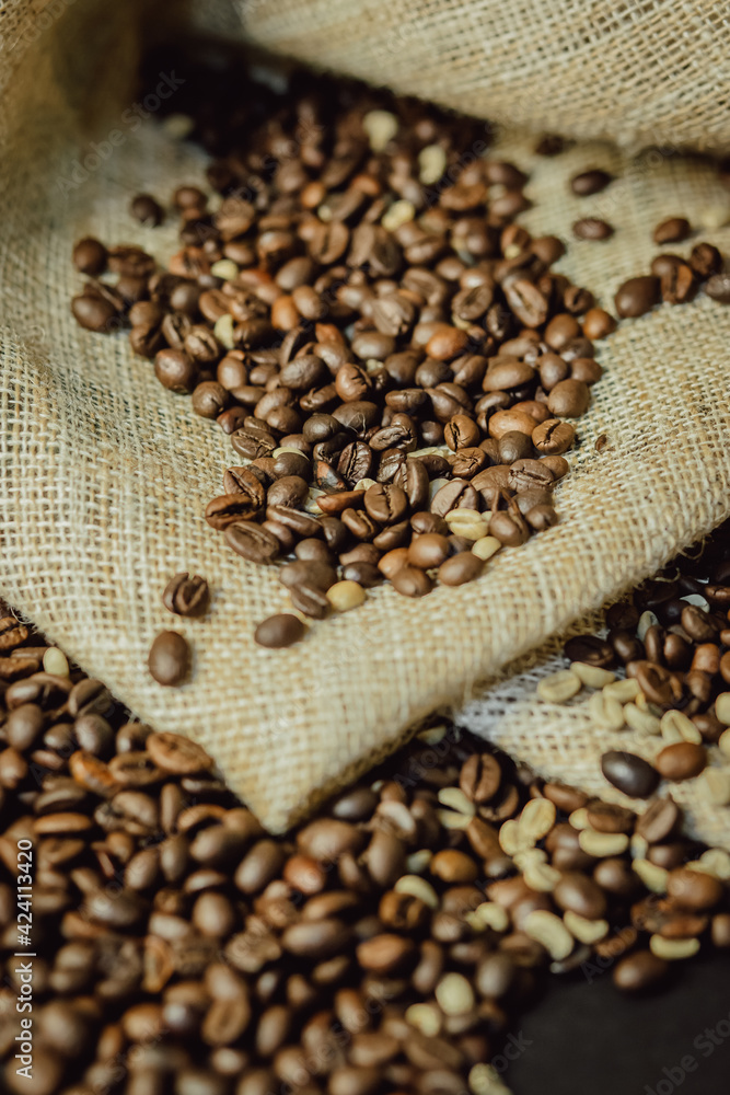 Roasted and green coffee beans on burlap closeup. Coffee beans background. Roasted and green coffee beans on burlap closeup. Coffee beans background.
