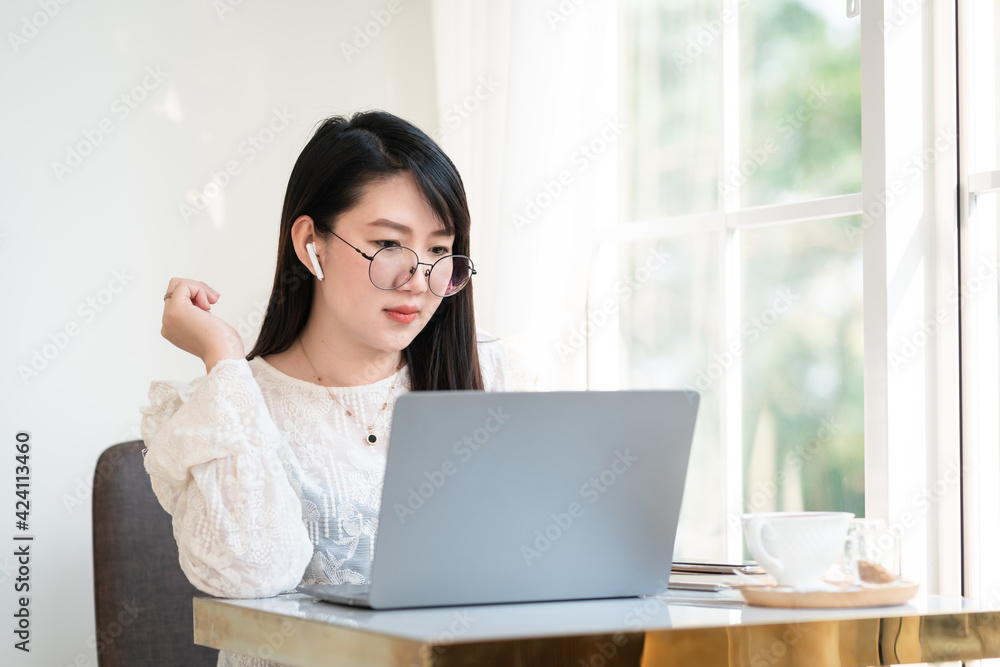 Happy of asian freelance people Businesswoman wearing wireless earphones casual working with laptop computer with a coffee cup mug,Notebook and smartphone at the cafe,Business Lifestyle communication Happy of asian freelance people Businesswoman wearing wireless earphones casual working with laptop computer with a coffee cup mug,Notebook and smartphone at the cafe,Business Lifestyle communication