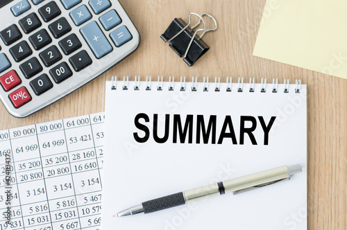 on notepad word SUMMARY on office desk