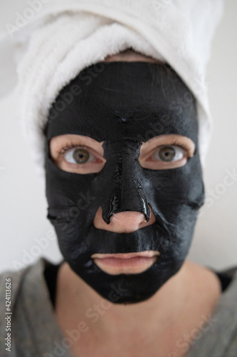 Schwarze Gesichtsmaske für Feuchtigkeit im Gesicht am Wellnesstag