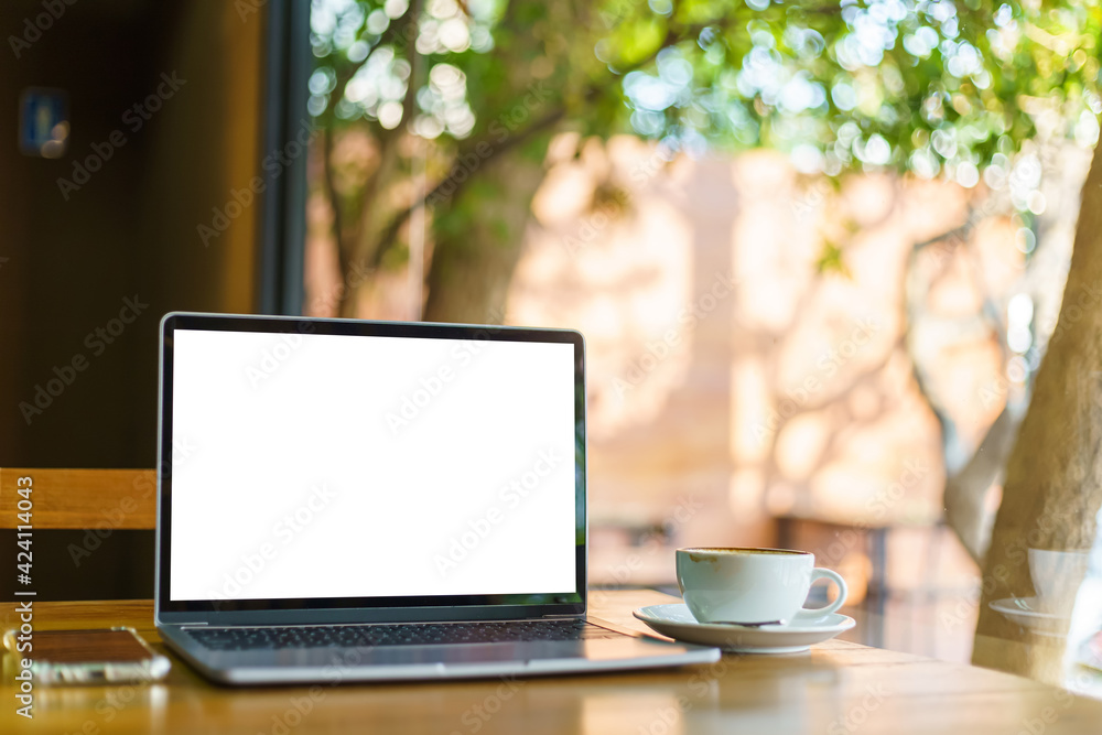Mockup of laptop computer with empty screen with coffee cup and smartphone on table of the coffee shop background,White screen Mockup of laptop computer with empty screen with coffee cup and smartphone on table of the coffee shop background,White screen