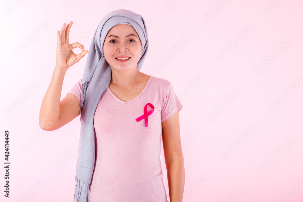 a asian women disease mammary cancer patient in pullover holding pink ribbon and hand showing ok sign isolated on pink blank copy space studio background,healthcare,medicine concept a asian women disease mammary cancer patient in pullover holding pink ribbon and hand showing ok sign isolated on pink blank copy space studio background,healthcare,medicine concept