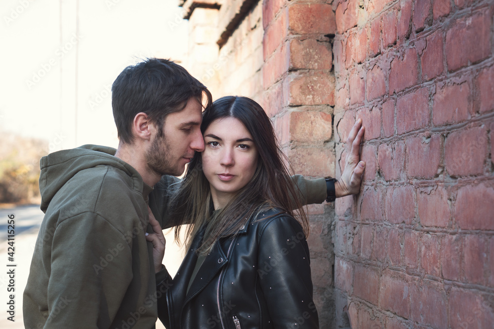 Handsome Bearded Man And Attractive Young Woman In Love. Having romantic. Lovers Posing Against the Wall. Spending Time Together. Concept Real People. Minimalist Urban Clothing Style