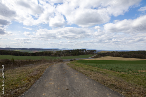 Ferner Blick über eine Landschaft mit Straßen und Windrädern am Horizont