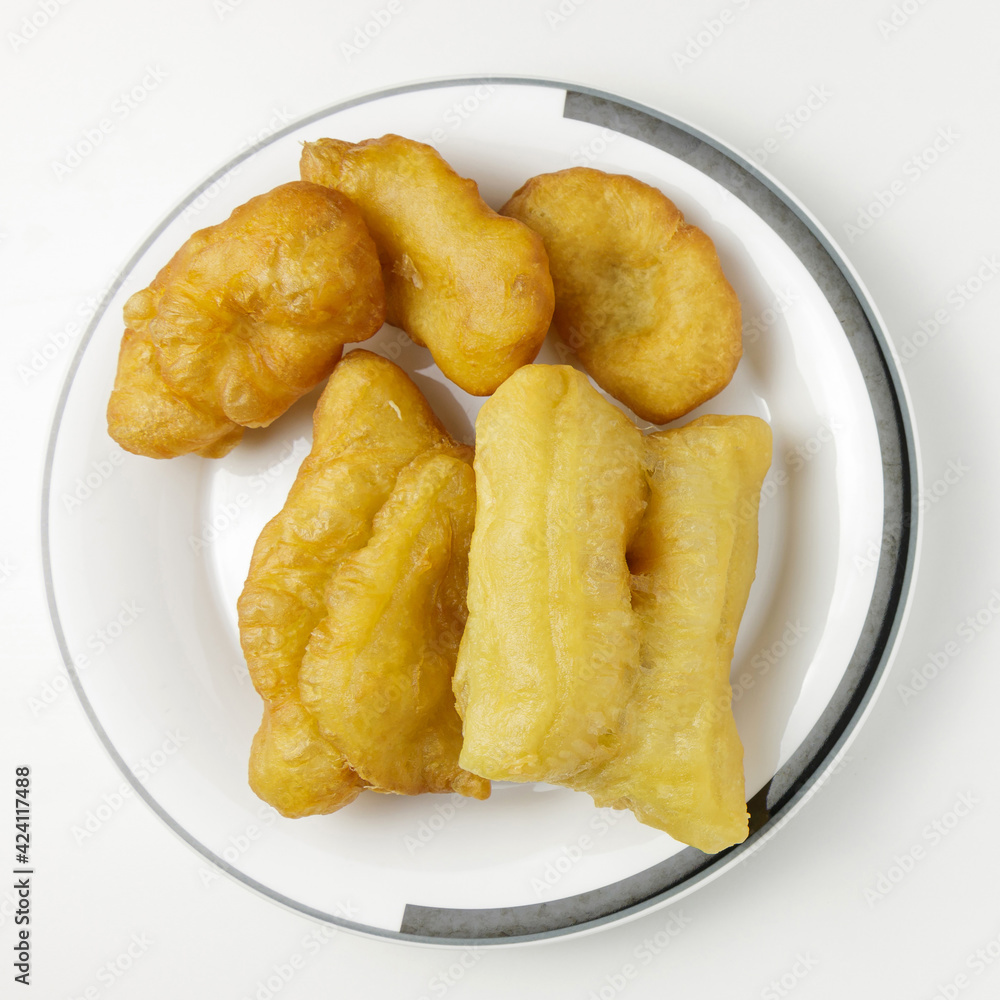 Deep-fried dough stick on a white dish isolated on a white background. Top view photography. The popular breakfast of the Thai. Deep-fried dough stick on a white dish isolated on a white background. Top view photography. The popular breakfast of the Thai.