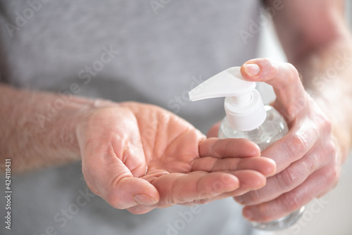 Hand pressing on sanitizer bottle; prevention of virus and bacteria infection