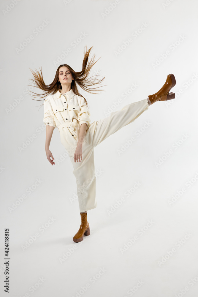 fashionable woman with her leg raised white jumpsuit isolated background fashionable woman with her leg raised white jumpsuit isolated background