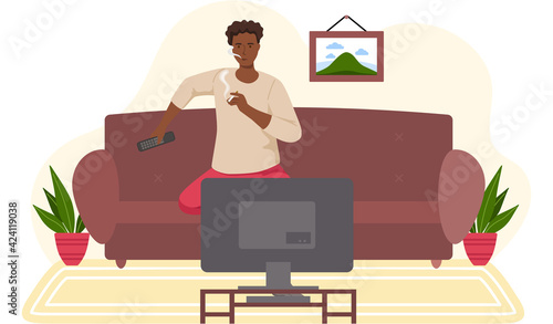 Guy with cigarette is relaxing alone and watching television. African man with TV remote smoking