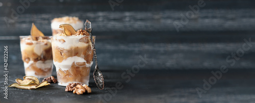 Foto Pear trifle, chocolate biscuit, layered dessert with caramel, pear and gentle cream cheese on grey background