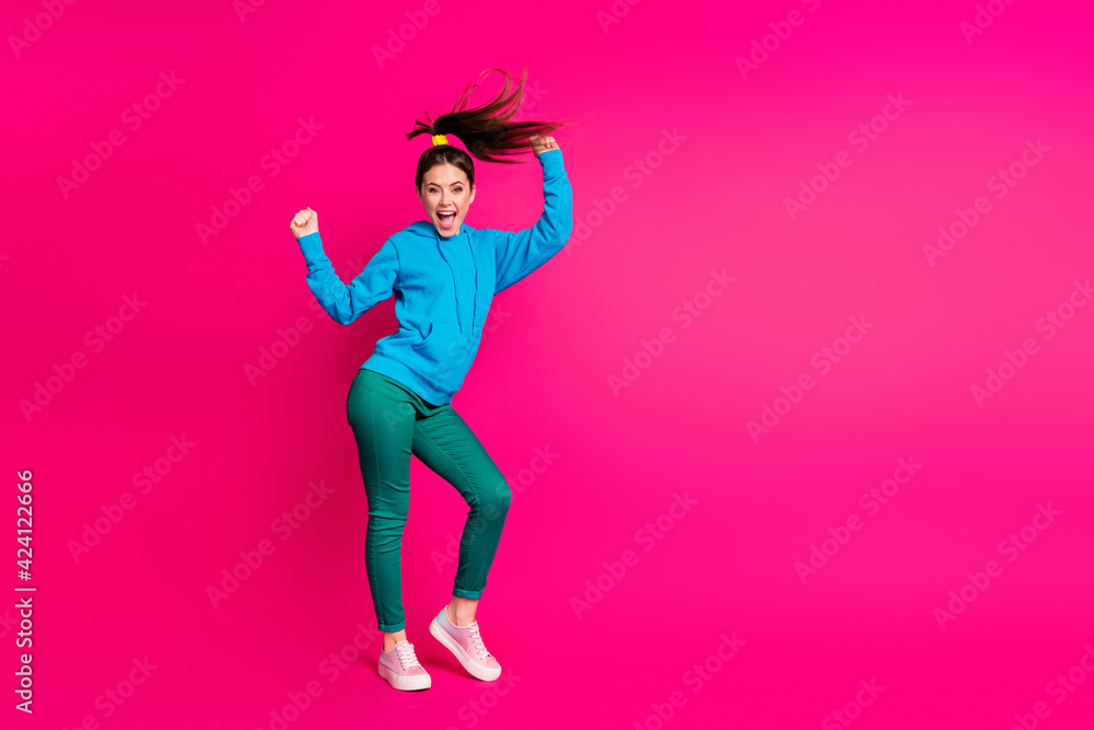 Full length photo of impressed young woman dressed blue hoodie dancing hands arms fists isolated vibrant pink color background Full length photo of impressed young woman dressed blue hoodie dancing hands arms fists isolated vibrant pink color background