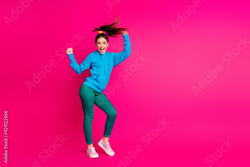 Fototapeta Naklejka Na Ścianę i Meble -  Full length photo of impressed young woman dressed blue hoodie dancing hands arms fists isolated vibrant pink color background
