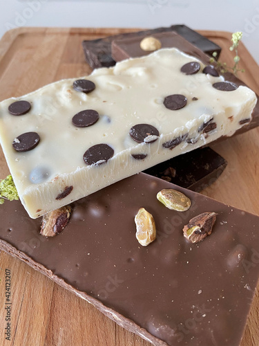 Photo of chocolates on a wood background. Dark, milk and white chocolate.