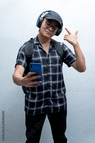 young man listening to music with his headphones taking a selfie