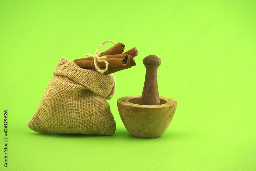 Cinnamon sticks bundle and wooden mortar with pestle