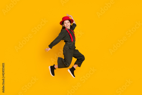 Full length body size view of attractive cheerful girl jumping having fun rejoicing isolated over bright yellow color background