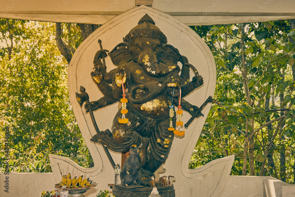 Fototapeta premium Phayao, Thailand - Dec 13, 2020: Zoom View Ganesha Statue and Incense Burner in Shrine at Wat Analayo Temple in Vintage Tone