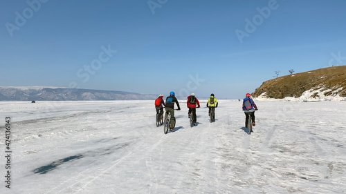 A group of cyclists on the frozen snow-covered Lake Baikal.