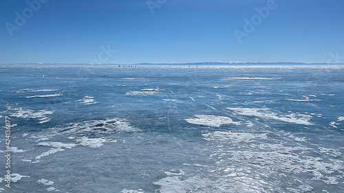 Panorama of the winter lake Baikal. People are skating. Beautiful winter landscape