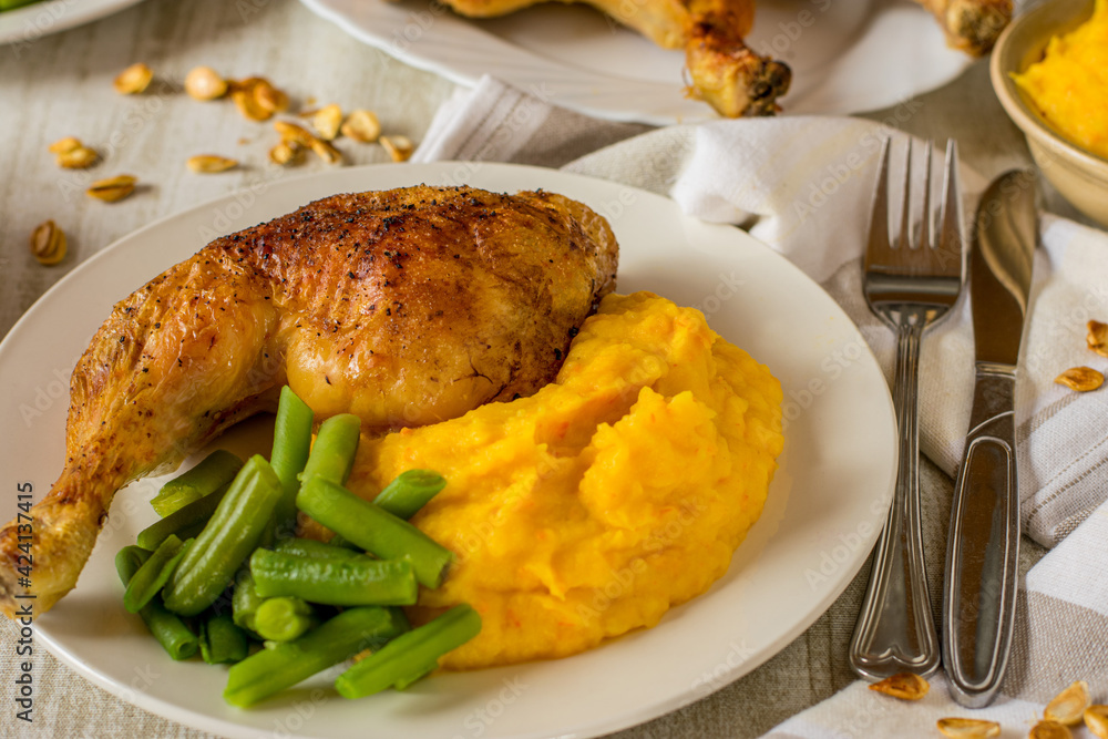 chicken dish with grilled thighs mashed potato pumkin puree and green beans served on a plate chicken dish with grilled thighs mashed potato pumkin puree and green beans served on a plate