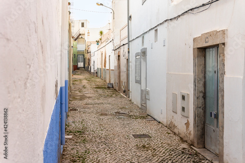 Small houses on the narrow street of historic Olhao, Algarve, Portugal © eunikas