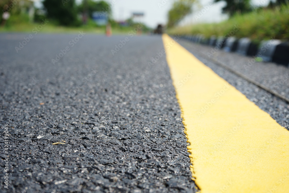 Fototapeta premium Yellow traffic lines and trees