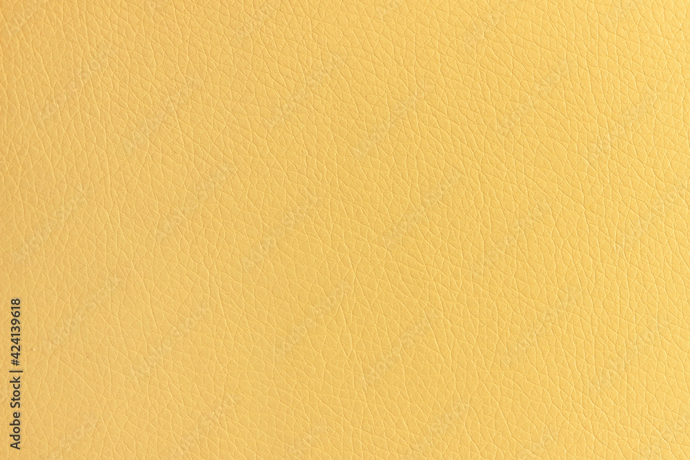 Naklejka premium The surface of artificial yellow leather used for furniture upholstery. Uniform light texture.