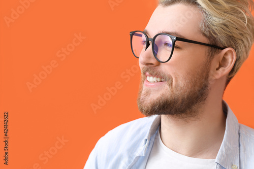 Fototapeta Naklejka Na Ścianę i Meble -  Young man wearing eyeglasses on color background