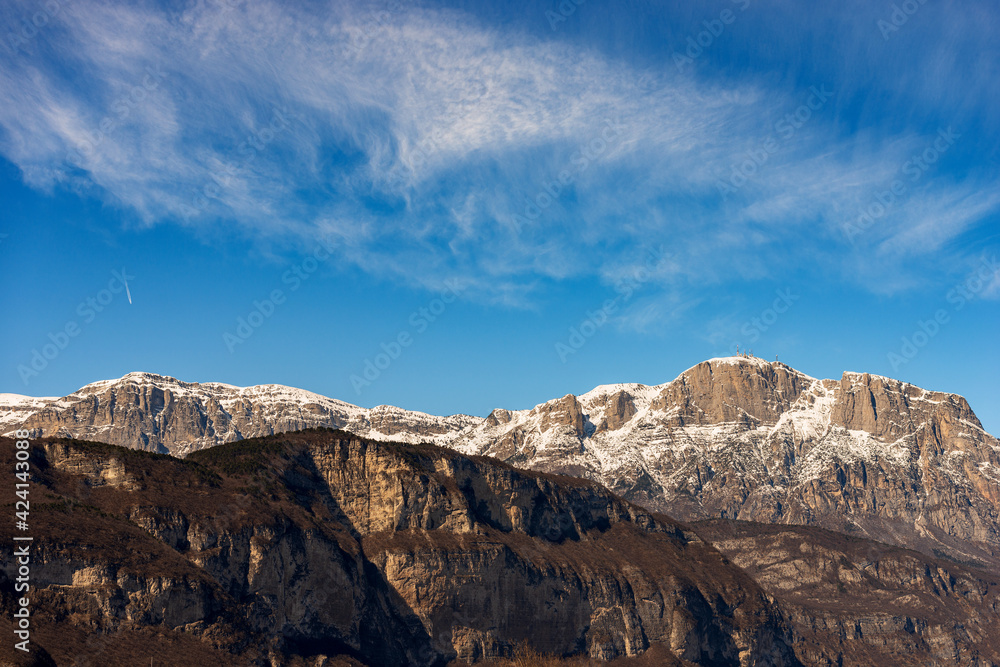 Snowcapped mountain range of the Paganella in winter with the Roda peak (2125 m) with the antennas of the weather station, seen from the Trento city, Adige Valley, Trentino Alto Adige, Italy, Europe.
