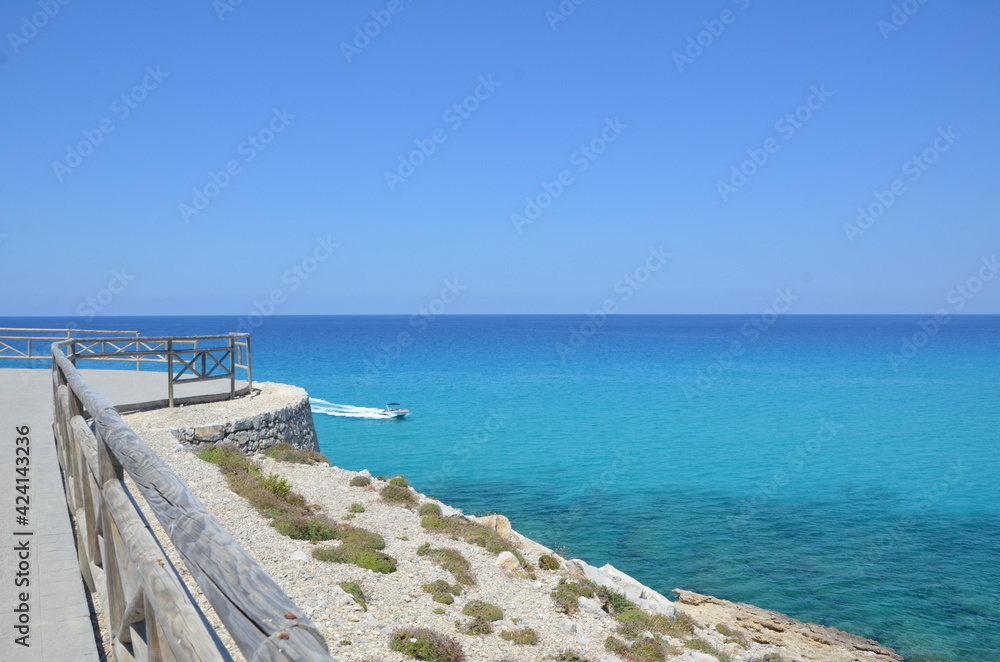 Beautiful sea view. Turquoise summer sea. Sea view from the stone pier. Boat at sea.